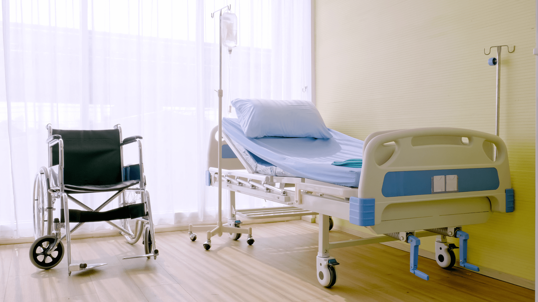 Adjustable hospital bed and wheelchair in a bright room, representing essential medical equipment for home care.